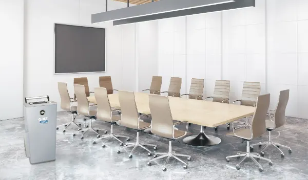 Konferenzraum mit langem rechteckigem Holztisch, zwölf drehbaren Bürostühlen mit hellbeigem Bezug und großem Flachbildschirm an der Wand.