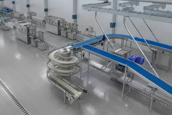 Große, moderne Lebensmittelproduktionsanlage mit Förderbändern und Edelstahlmaschinen in hellem Raum.
