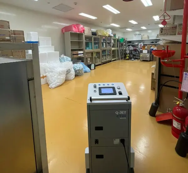 Flur mit Holzregalen und offener Tür, Boden steht unter stehendem Wasser, Decke mit sichtbaren Rohren und Kabeln.